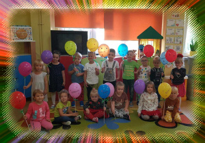 Na zdjęciu grupa dzieci. Każde z nich trzyma balonik w kropki.